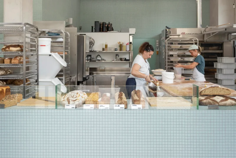 What the Bread bakery, Saint-Denis, by MUR.MUR Architectes: sourdough loaves in glass counter, open lab behind. Photo: Yvan Moreau