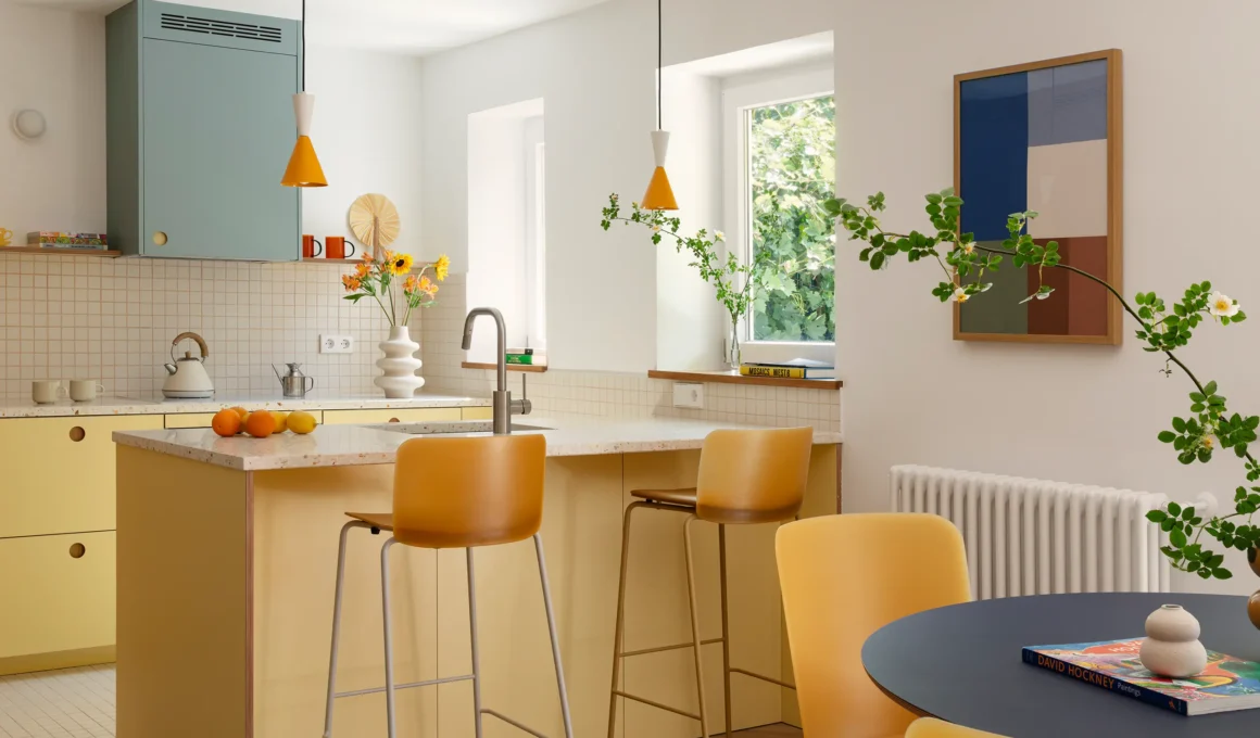 Casa Boa kitchen by Paula Ábalos arquitectura with pastel-yellow cabinetry, terrazzo island and blue extractor hood. Photography: Sergio Pradana