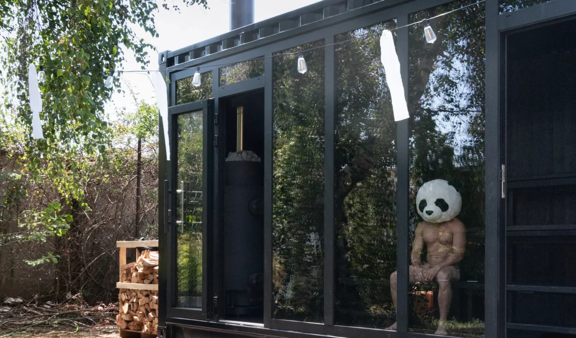 Pixxla Sauna by Zly Architekt, Bratislava, glazed shipping container facade with visible sauna stove. Photo: Zly Fotograf