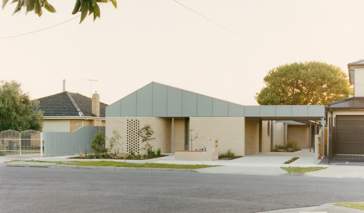 SDA Housing Project by Studio Bright, Melbourne, brick facade with pitched metal roof and timber gate. Photo: Gavin Green