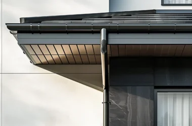 Aluminium guttering integrated into a dark modern facade with concealed downpipe