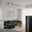 Apartment No. 201 by Anastasiou Misseri, living room with green velvet modular sofa and amber glass coffee table in Nicosia