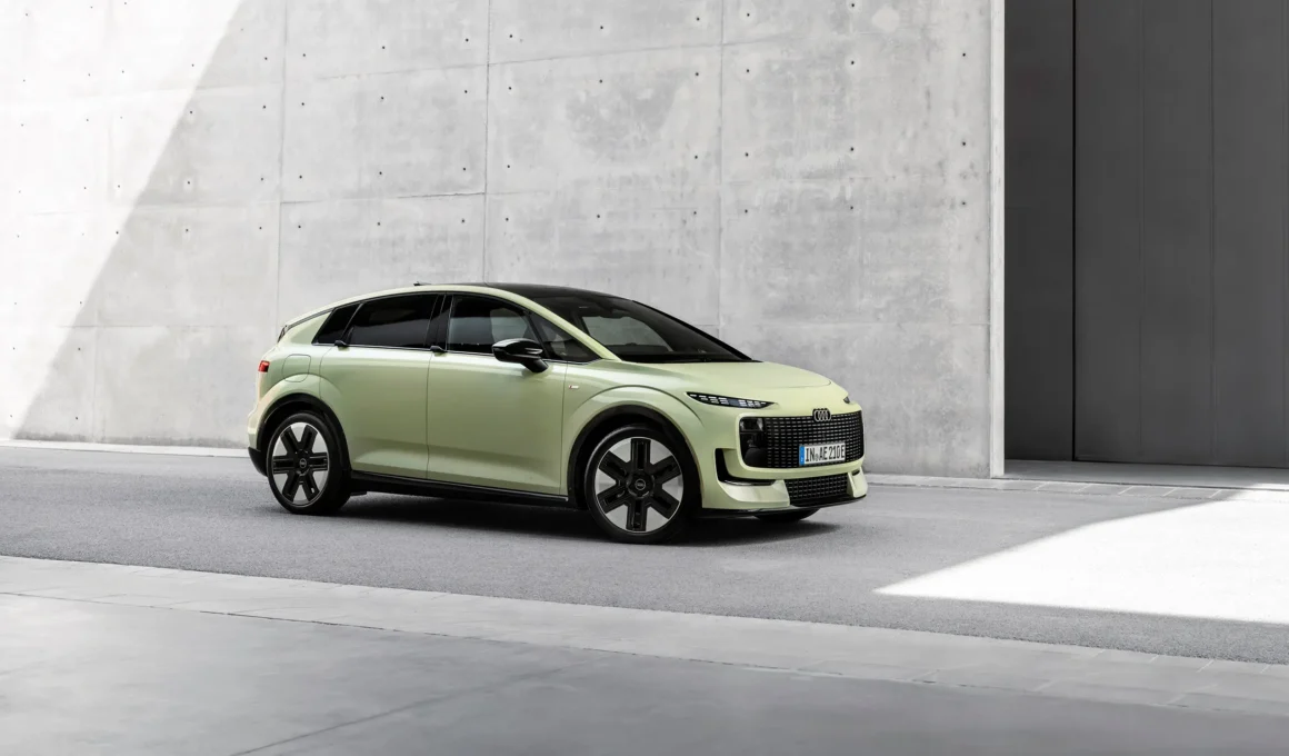 Audi A2 e-tron in pale green, three-quarter front view against a concrete wall
