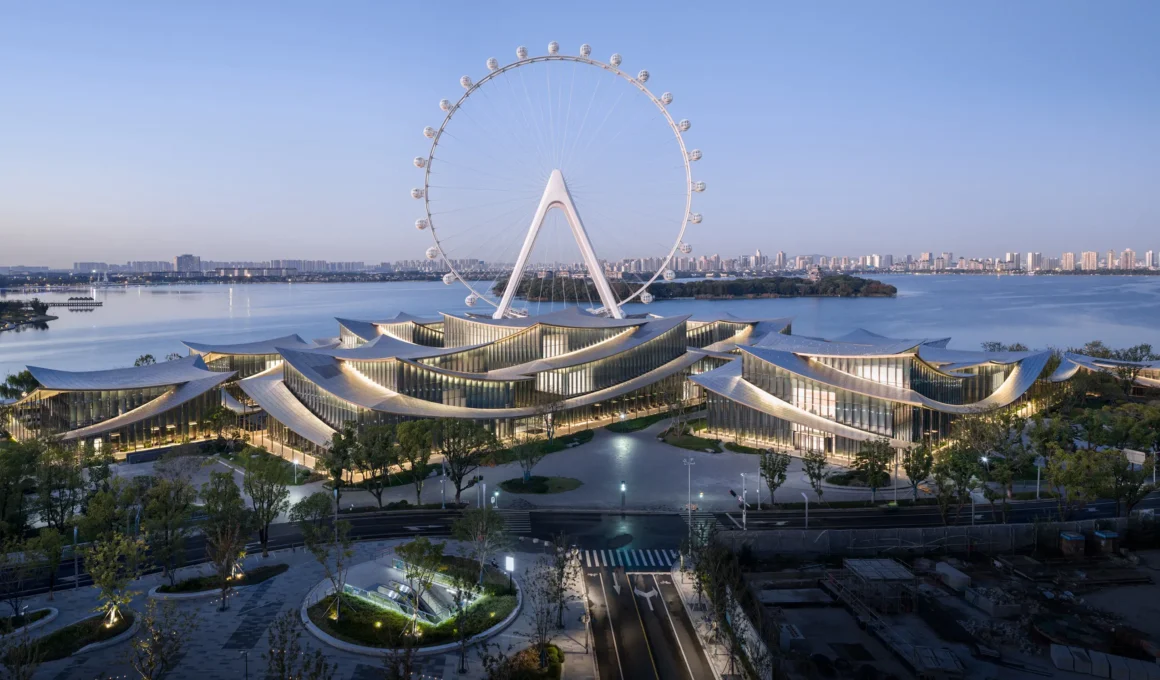 Suzhou Museum of Contemporary Art by BIG at dusk, undulating roof pavilions beside the Suzhou Ferris wheel and Jinji Lake
