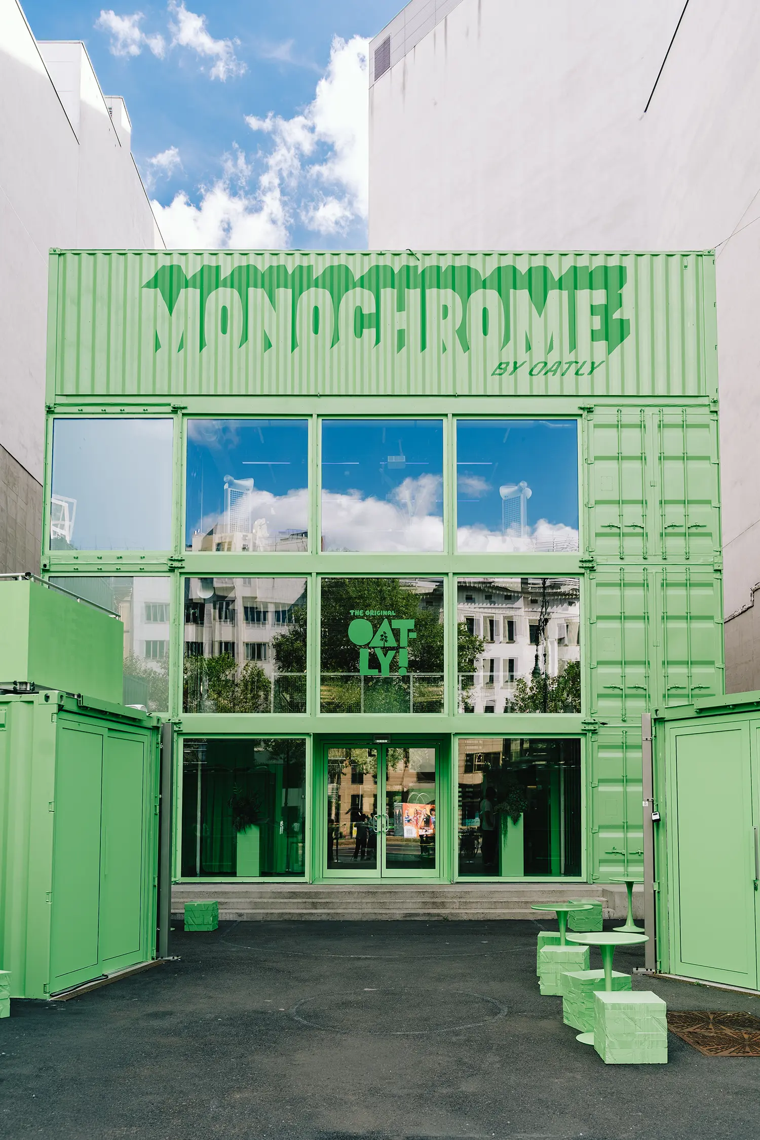 Stacked green shipping containers with glazing at Monochrome by Oatly by Cee Cee Creative, Berlin. Photo: Aditya Christian, Mohit Amlani