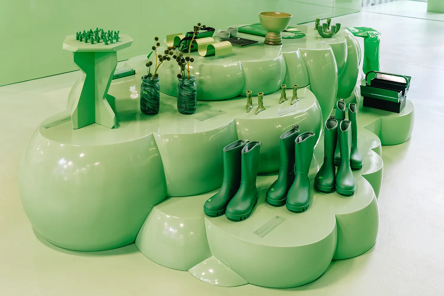 Cloud-shaped plinth with green boots and vases at Monochrome by Oatly by Cee Cee Creative. Photo: Aditya Christian, Mohit Amlani