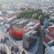 Jihlava Municipal Arena by CHYBÍK + KRIŠTOF, aerial view of the red perforated arena, silver cube and rooftop running track