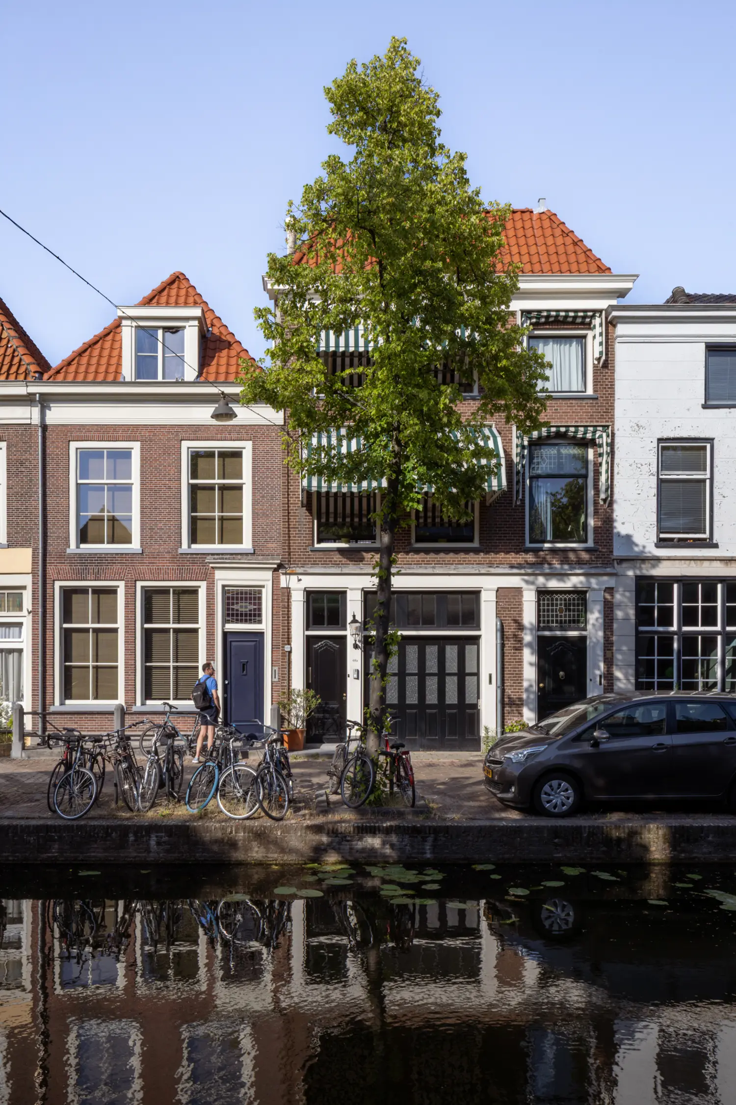 Canal-facing brick façade of the Rear House renovated by DP6 architectuurstudio in Delft, with entrance and garage