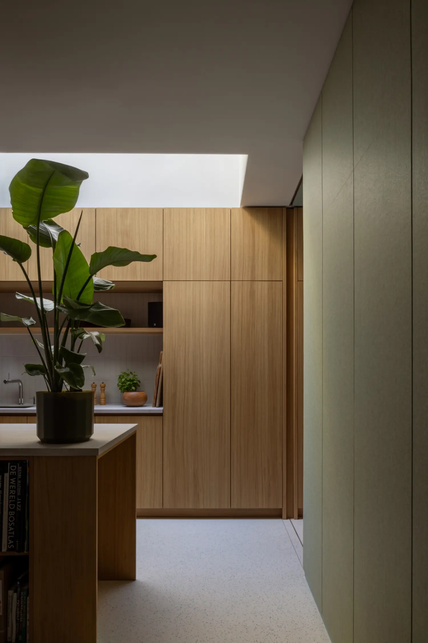 Oak kitchen inside the renovated Rear House, DP6 architectuurstudio, Delft, lit by an overhead skylight