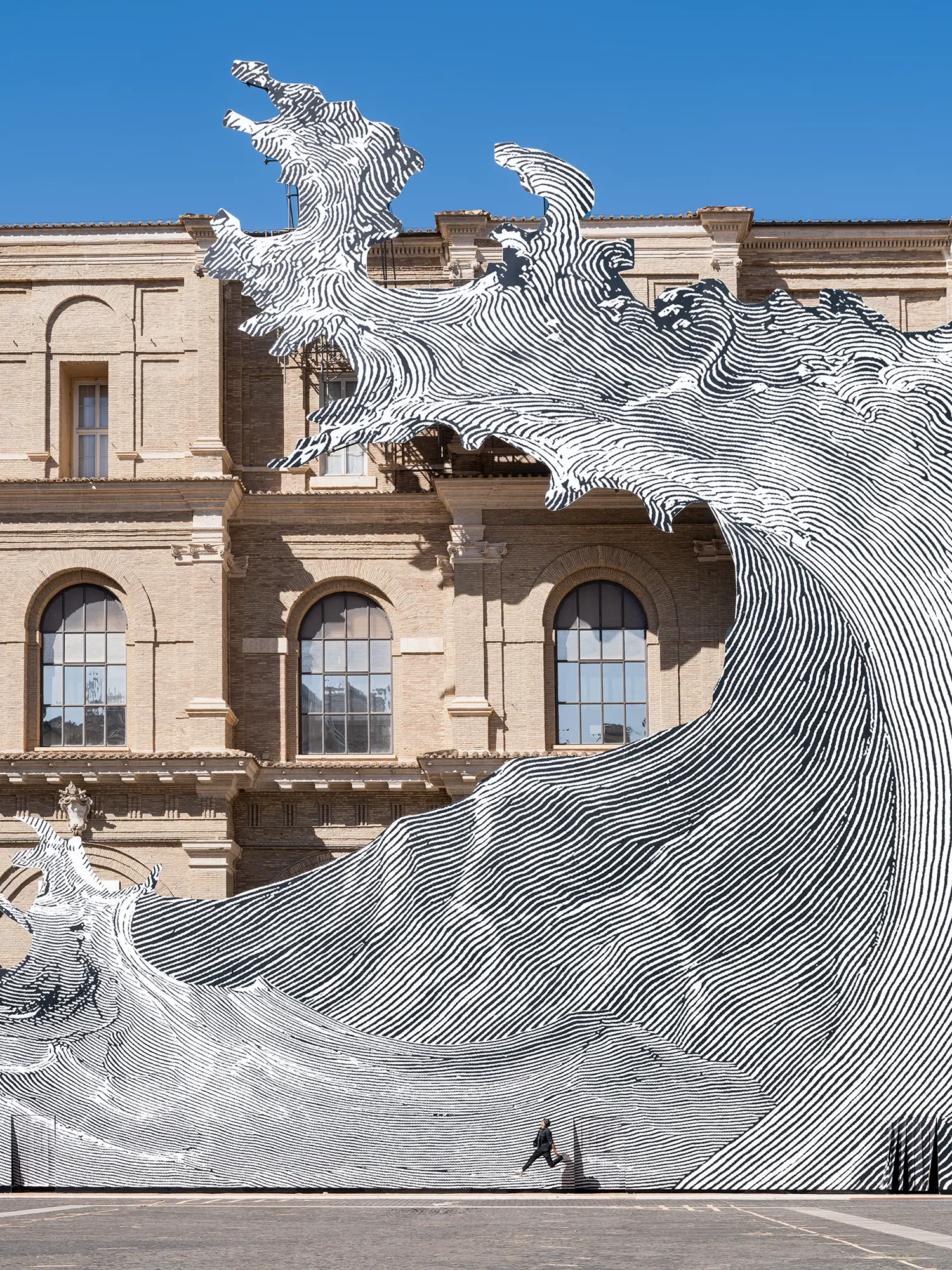 Close-up of JR's Diluvium at the Vatican Apostolic Library, cut-out wave crest rising above the roofline in front of arched windows