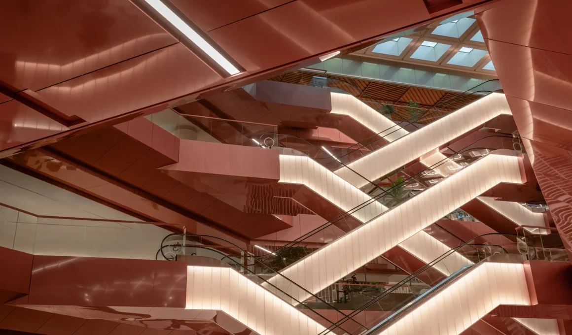 Central Park Bangkok by Linehouse, Copper Void escalators with backlit copper-toned cladding beneath a triangulated skylight