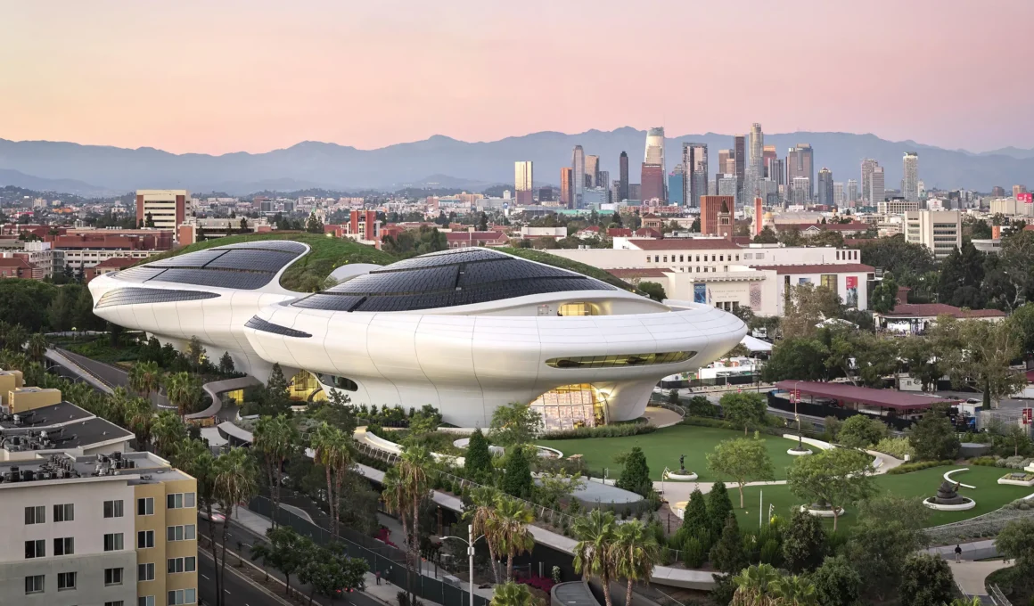 Lucas Museum of Narrative Art by MAD at dusk, aerial view over Exposition Park with green roof and solar panels; photo by Hufton+Crow