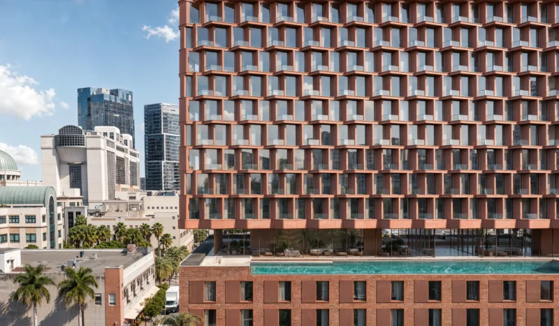 MiMar by CRA-Carlo Ratti Associati, terracotta zig-zag façade balconies above rooftop pool, West Palm Beach skyline