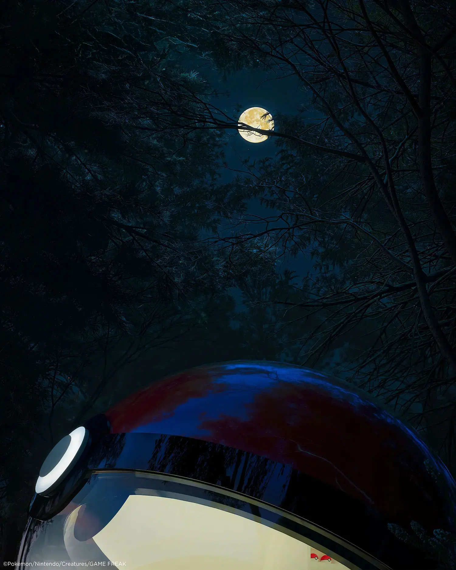 Upper shell of the Poké Ball-Themed Hotel by NOT A HOTEL ARCHITECTS at night, lit interior below a full moon in the forest