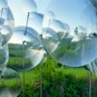 Eccentric Lenses by Vincent Leroy, overlapping circular Fresnel lenses on slim vertical supports above rice terraces in Munduk, Bali
