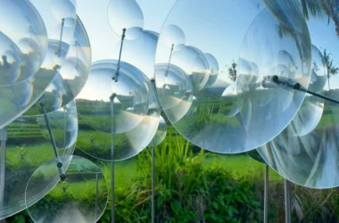 Eccentric Lenses by Vincent Leroy, overlapping circular Fresnel lenses on slim vertical supports above rice terraces in Munduk, Bali