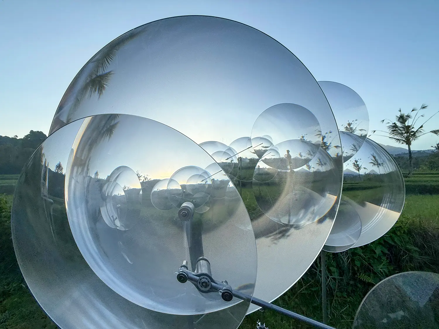 Eccentric Lenses by Vincent Leroy, close view of a large Fresnel lens and its pivot joint at dusk, Munduk, Bali